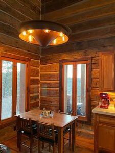 Cozy log cabin kitchen and dining area with wooden accents, warm lighting, and rustic charm.